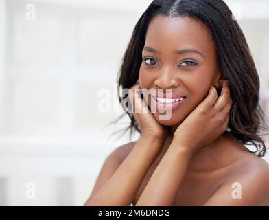 Uso solo il meglio sulla mia pelle. Una giovane donna durante il suo rituale quotidiano di bellezza. Foto Stock