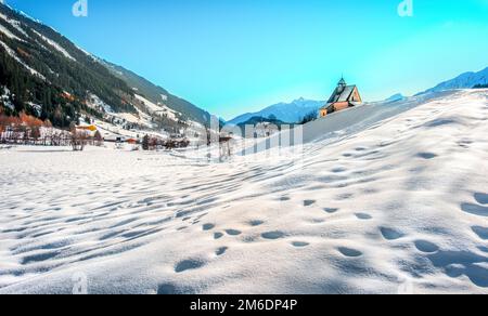 Paesaggio montano, pittoresche impronte di neve nella chiesa panoramica della mattina invernale Foto Stock