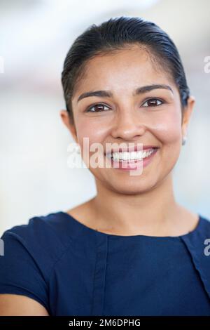 Il successo mi fa sorridere. Primo piano ritratto di una giovane donna d'affari attraente nel suo ufficio. Foto Stock