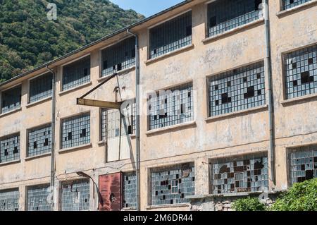 Vecchia facciata industriale obsoleta con finestre rotte Foto Stock