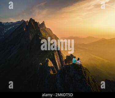 Coppia al siepe di una montagna che guarda il tramonto, Schaeffler cresta di montagna swiss Alpstein, Appenzell Svizzera, un ripido cresta della maestosa cima Schaeffler, Foto Stock