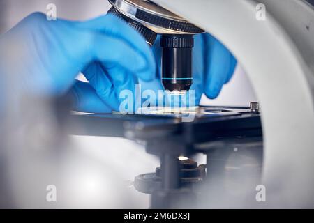 Microscopio, mani scientifiche e scientifiche, analisi di dati o campioni di DNA, studio di ricerca in microbiologia o biotecnologia. Particelle zoom, batteri e. Foto Stock