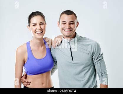 Avere un partner rende tutto più facile. Ritratto di una giovane coppia sportiva su sfondo bianco. Foto Stock