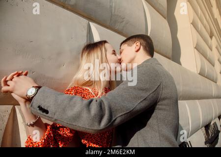 Concetto di relazioni d'amore uomo e donna. Bella coppia che cammina nella grande città, abbracciandosi, baciandosi e godendosi a vicenda. Foto Stock