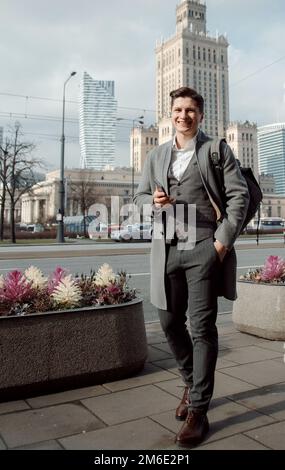 Felice gente di affari, che lavora fuori, imprenditore e tecnologia di comunicazione di libertà di lavoro.Un tipo in una cuffia auricolare in una grande città Foto Stock