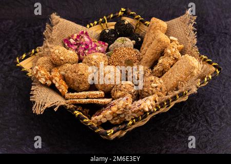 Gulab Gajak Mithai, pista Gazak, Til Patti o Papdi, Til Laddu o Ladoo, Revdi e Rewri di Tilgul, Mungfali, seme di Sesamo, God gelatinoso, Badam e. Foto Stock