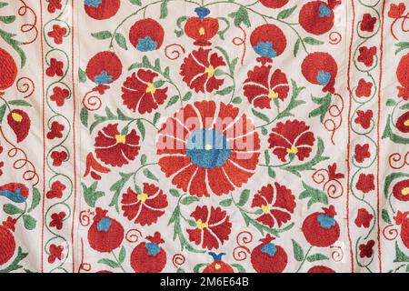 Parte della tessitura del tappeto, ornamento astratto. Ricamo tradizionale floreale su tappeto leggero. Ricamo in satinato floreale fatto a mano. Immagine primo piano Foto Stock