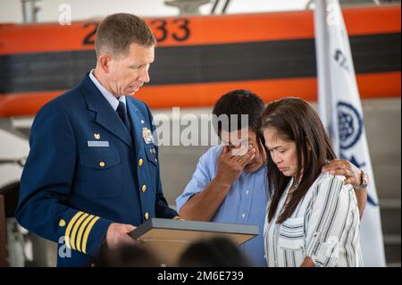 Jason Smith, comandante del settore Houston-Galveston, presenta una lettera di apprezzamento a Jessica Reyes Posana ed Erneto Posana, genitori di Elia Posana, in occasione di una cerimonia in onore del figlio al Coast Guard Marine Safety Security Team Houston, Texas, 26 aprile 2022. Durante la cerimonia, Posana ha ricevuto postumo la Medaglia di Airman per aver salvato i suoi cugini da una corrente di rip a Surfside Beach, Texas, il 2 maggio 2021. Foto Stock