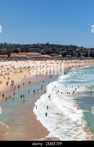 Estate 2023, Bondi Beach Sydney in una giornata di estate con cielo blu chiaro, spiaggia piena e affollata con persone che prendono il sole e nuotano, Sydney, NSW, Australia Foto Stock