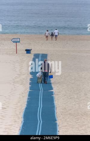 Torreira Aveiro Portugal - 08 07 2022 : Vista di un uomo anziano che cammina sul sentiero dello stand, la famiglia che cammina sulla spiaggia e si sposta verso il mare, atl Foto Stock