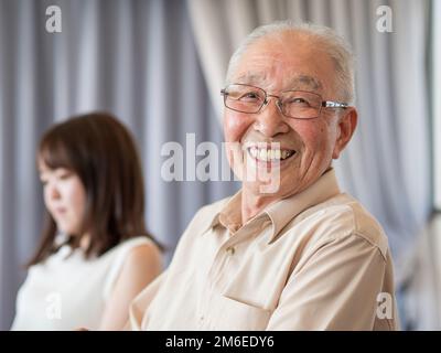 Un vecchio che parla animatamente ad un evento di famiglia Foto Stock