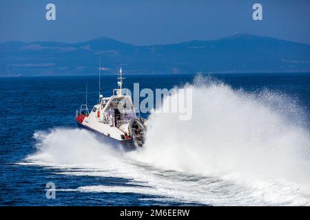 Una barca della Guardia Costiera va ad alta velocità attraverso l'area acquatica di Vladivostok Foto Stock