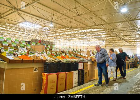 Acquirenti, clienti che guardano vari frutti secchi e spezie in una bancarella locale. Al mercato di Tavira, Mercado a Tavira, Algarve, Portogallo, Europa. Foto Stock