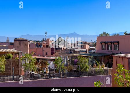 Sopra i tetti a Marrakech. Ripresa dalla terrazza sul tetto della Maison des Epices. Minareti a moderni pannelli solari; palme a piatti satellitari. Foto Stock