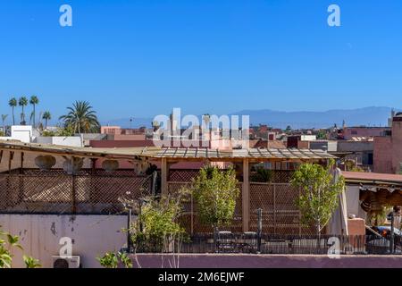 Sopra i tetti a Marrakech. Ripresa dalla terrazza sul tetto della Maison des Epices. Minareti a moderni pannelli solari; palme a piatti satellitari. Foto Stock