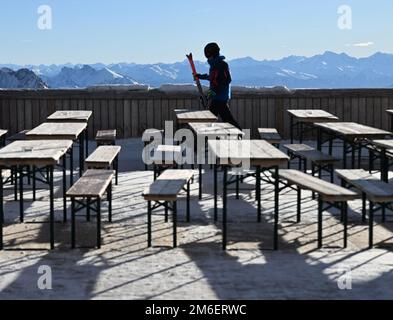 Grainau, Germania. 04th Jan, 2023. Uno sciatore cammina sulla terrazza vuota dello Zugspitzplatt. Credit: Angelika Warmuth/dpa/Alamy Live News Foto Stock