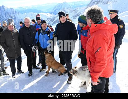 Grainau, Germania. 04th Jan, 2023. Il primo ministro bavarese Markus Söder (CSU, M) parla con gli esperti dello Zugspitzplatt durante una dimostrazione pratica sulla ricerca di vittime di valanghe. Esperti del Club Alpino Tedesco, del Servizio Soccorso in montagna, dell'Associazione tedesca istruttori di Sci, del Servizio Avvertenze valanghe e delle guide alpine della polizia si sono incontrati per una conferenza stampa sulla sicurezza alpina. Credit: Angelika Warmuth/dpa/Alamy Live News Foto Stock