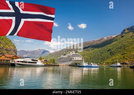 Porto di Flam con nave da crociera di lusso contro la bandiera della Norvegia. Foto Stock