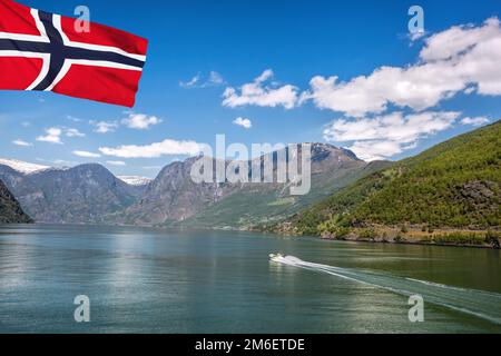 Porto di Flam con barca turistica nel fiordo con bandiera di Norvegia Foto Stock