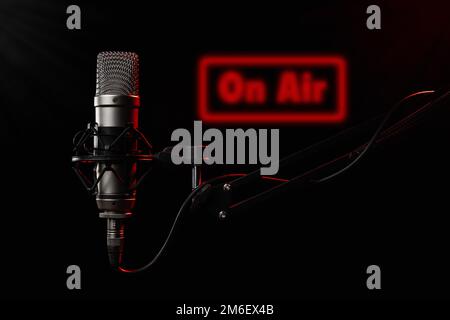 Ampio microfono a diaframma per podcast su sfondo nero con luce rossa Foto Stock