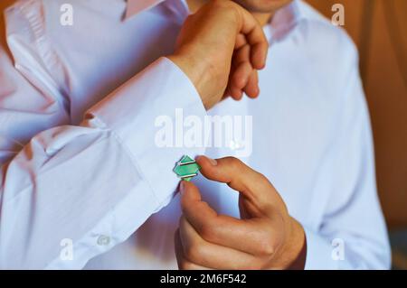 L'uomo indossa un gemelli su una camicia bianca. Foto Stock