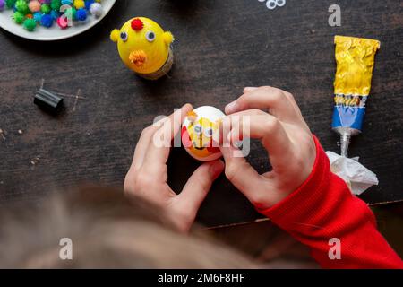 Ragazza che fa figurine da uova, vista dall'alto Foto Stock