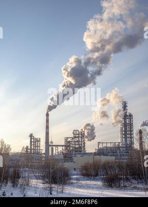 Il lavoro di un impianto petrolchimico. Il fumo proviene dal camino. Foto Stock