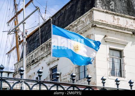 Bandiera argentina sullo sfondo di un vecchio edificio storico. Blu e bianco simbolo nazionale della cultura e del patriottismo argentini. Foto di alta qualità Foto Stock