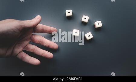 Gettando i dadi su uno sfondo grigio scuro. Foto Stock