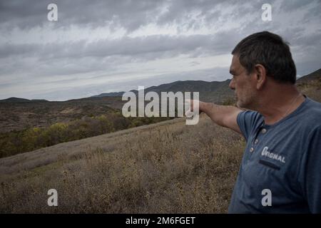 Giorgi Begiashvili (50) vicino al territorio occupato, mostrandomi un villaggio Ossezio già occupato dai russi. Come Giorgi ha detto in circa 100 metri ci sono russi, che controllano il territorio occupato e recinzioni spinato di filo metallico che vengono spostate di volta in volta, ci sono stati molti casi in cui guardie russe rapiti persone, come gli abitanti del villaggio sono spaventati vivere nella zona di paura, a Mejvriskhevi, Georgia il 15 ottobre 2022. Sono passati 14 anni dalla seconda invasione della regione dell'Ossezia meridionale della Georgia. La seconda volta che le forze militari russe hanno preso con successo il territorio, è iniziato Foto Stock