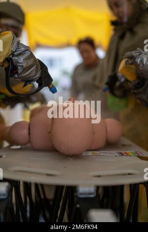 STATI UNITI I marinai assegnati alla Robert M. Casey Naval Family Branch Clinic Iwakuni decontaminano un incidente simulato durante un primo corso di formazione per le operazioni di Risposta alla Marine Corps Air Station Iwakuni, Giappone, 27 aprile 2022. In questo corso, il personale della clinica pratica la decontaminazione dei pazienti prima di effettuare la cura, proteggendo l'individuo da ulteriori pericoli. Questa formazione annuale viene utilizzata come aggiornamento per garantire che il corpman familiarizzi con le procedure e sostenga la preparazione generale. Foto Stock