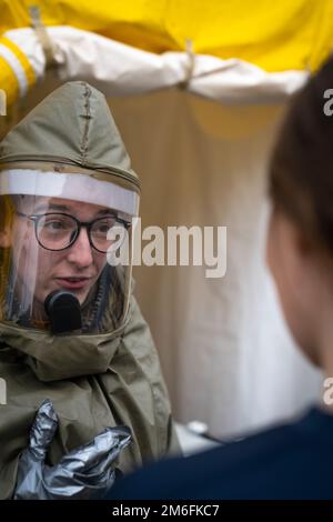 NEGLI STATI UNITI Il marinaio assegnato alla Robert M. Casey Naval Family Branch Clinic Iwakuni passa attraverso le procedure con un paziente durante un primo corso di formazione per le operazioni di Risposta presso la Marine Corps Air Station Iwakuni, Giappone, 27 aprile 2022. In questo corso, il personale della clinica pratica la decontaminazione dei pazienti prima di effettuare la cura, proteggendo l'individuo da ulteriori pericoli. Questa formazione annuale viene utilizzata come aggiornamento per garantire che il corpman familiarizzi con le procedure e sostenga la preparazione generale. Foto Stock