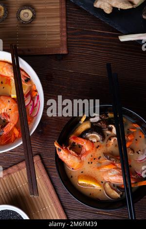 Minestra di miso con cozze, gamberetti, funghi shiitake e vegatables. servito al tavolo di legno marrone scuro. giacitura piatta Foto Stock