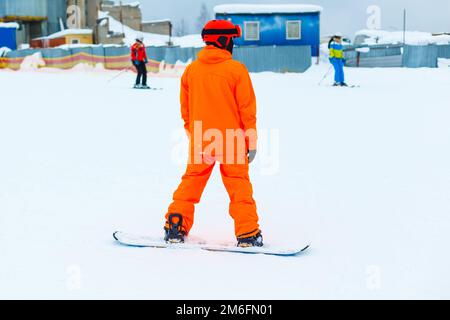 Foto di un giovane uomo con uno snowboard all'aperto. Foto Stock