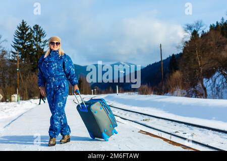 donna in tute da sci si trova vicino alla ferrovia Foto Stock