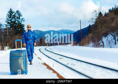 donna in tute da sci si trova vicino alla ferrovia Foto Stock