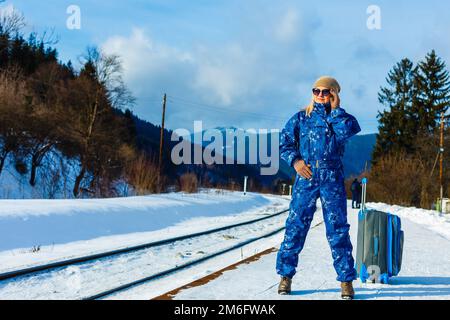 donna in tute da sci si trova vicino alla ferrovia Foto Stock