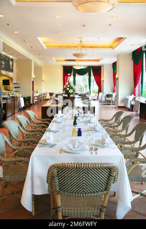 lungo tavolo riservato ristorante, sedia di lusso ristorante e tavolo completo di tovaglioli e cutleries pronti a servire gli ospiti Foto Stock