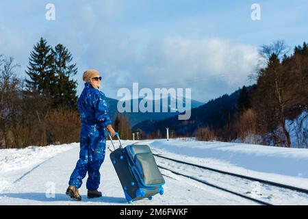 donna in tute da sci si trova vicino alla ferrovia Foto Stock