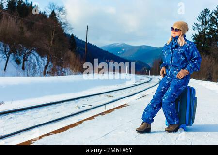 donna in tute da sci si trova vicino alla ferrovia Foto Stock