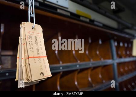 Vista interna di un carrozza postale su un treno a vapore d'epoca con slot per la posta e tag Foto Stock