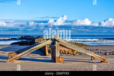 Lossiemouth East Beach Moray costa Scozia resti di legno del vecchio molo sulla spiaggia sabbiosa Foto Stock