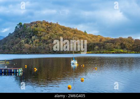 Yacht ormeggiato a Bandry Bay, che separa la piccola isola boscosa di Inchtavannach da Aldochlay, sulla sponda occidentale di Loch Lomond in Scozia, Regno Unito Foto Stock