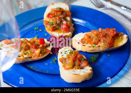 La bruschetta è un antipasto italiano composto da pane alla griglia strofinato con aglio e condito con olio d'oliva e sale. Foto Stock