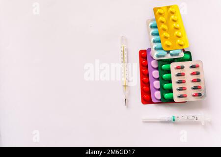 Apparecchiature mediche varie, termometro, ampolle, pipetta, farmaci, compresse, capsule, spray, cerotto, siringa, fiale su sfondo bianco. Medicina, Foto Stock