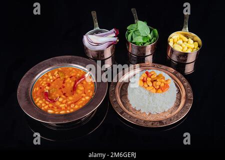 Cibo turco sul tavolo fagiolo al forno pilaf (fagioli blu scuro e riso). Cucina tradizionale locale con vista dall'alto. Alimenti turchi; fagiolo essiccato (kuru Foto Stock