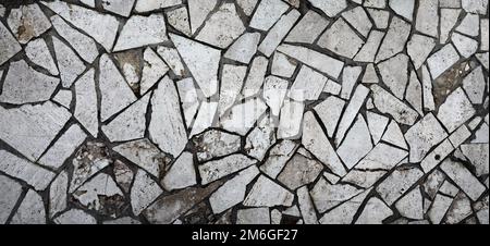 Pavimento in marmo Mosaico a grunge scuro. Texture fatta di diversi pezzi di piastrelle rotte. Foto panoramica ampia Foto Stock