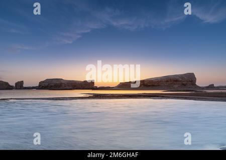 Forma di terra di Yardang sull'acqua al tramonto Foto Stock
