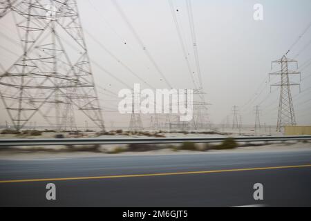 I piloni elettrici passano nel deserto Foto Stock