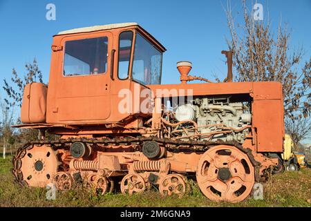 Un vecchio trattore cingolato rosso agricolo fabbricato in URSS Foto Stock
